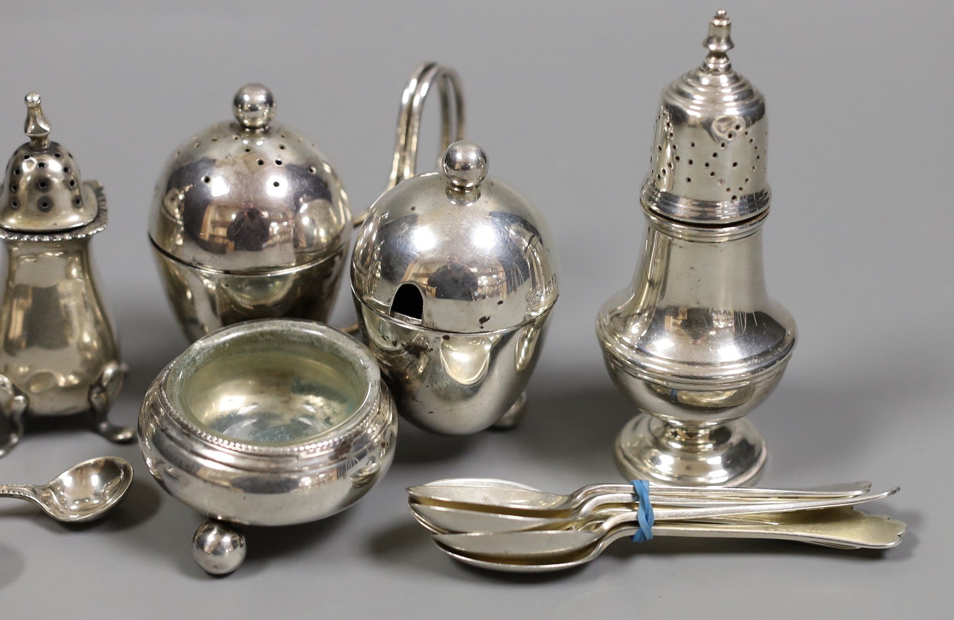 An Edwardian silver cruet stand, by Goldsmiths & Silversmiths, London, 1901, four other silver condiments and a set of six silver coffee spoons.